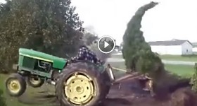 john deere tractor tearing down a pine tree
