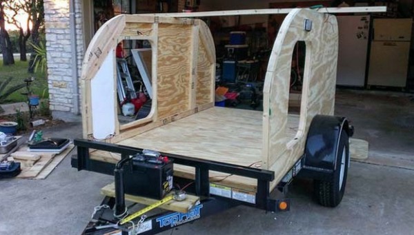 Unexperienced man assembles a trailer completely on his own - side wooden boards attached