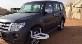 Mitsubishi SUV with toilet seat on the front wheel - cl