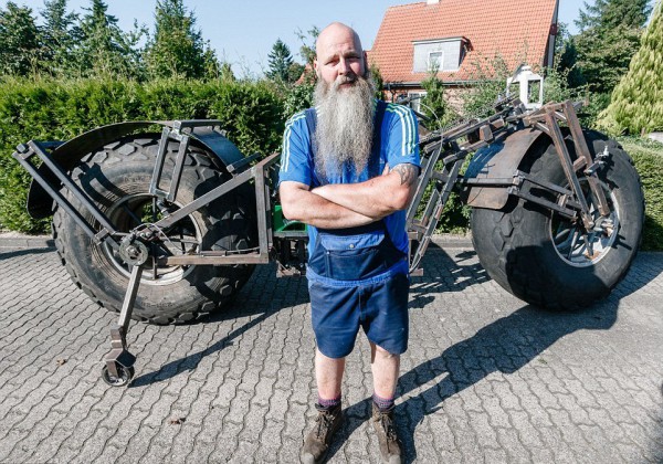 Frank Dose standing in front of his largest bicycle of the world