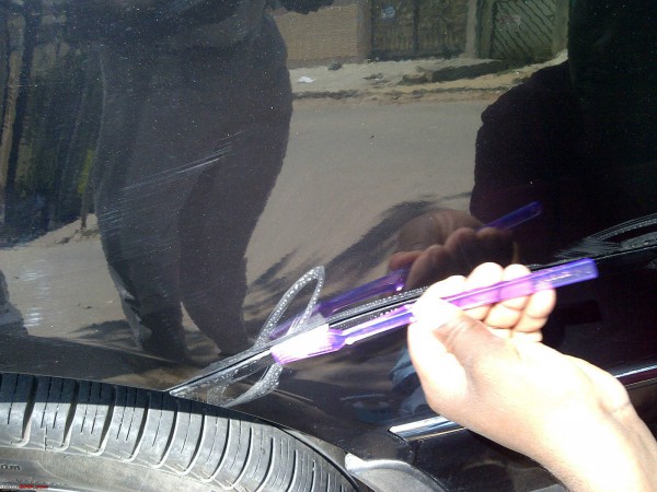 hand washing car with toothbrush