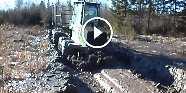 Forwarder John Deere 1110D grading muddy icy off road