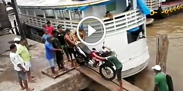 Loading a motorbike on ship over two boards