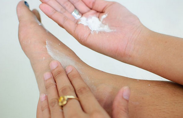 Applying nutritious cream on feet