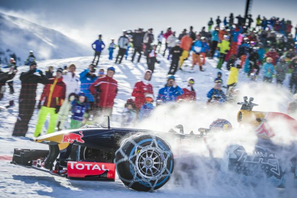 Max Verstappen driving a Red Bull RB7 F1 car on snow close up side view