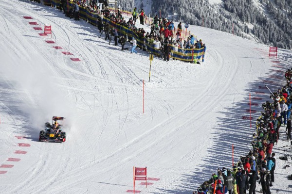 Max Verstappen driving a Red Bull RB7 F1 car on snow front distant view