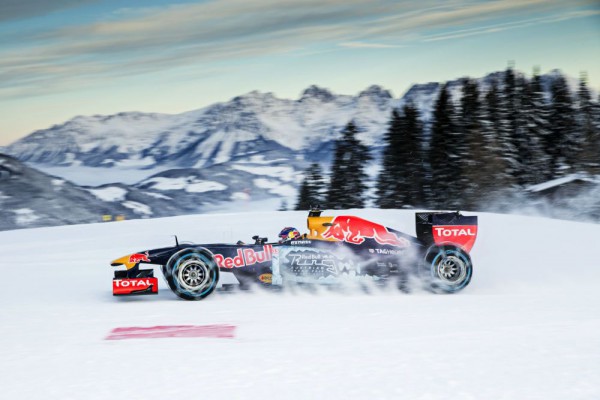 Max Verstappen driving a Red Bull RB7 F1 car on snow side view 1